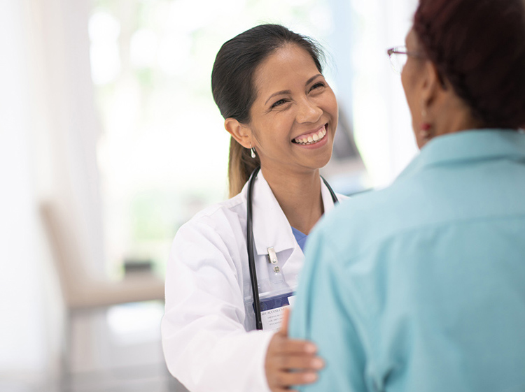 A doctor speaking with a person in a sky blue shirt