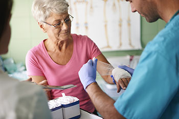 An older woman getting prepared to have her blood drawn