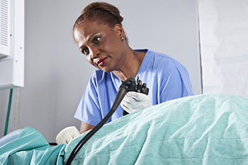 A doctor looking over a patient in bed